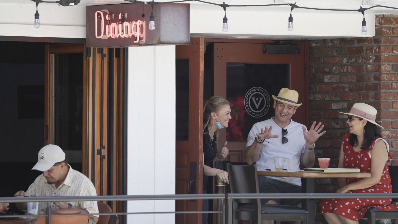 In this file photo from May 24, 2020, patrons enjoy drinks outdoors at a restaurant during the Memorial Day weekend on Balboa Island in Newport Beach. Orange County officials announced a program Thursday that will reward restaurants that comply with COVID-19 guidelines. (AP Photo/Marcio Jose Sanchez, File)