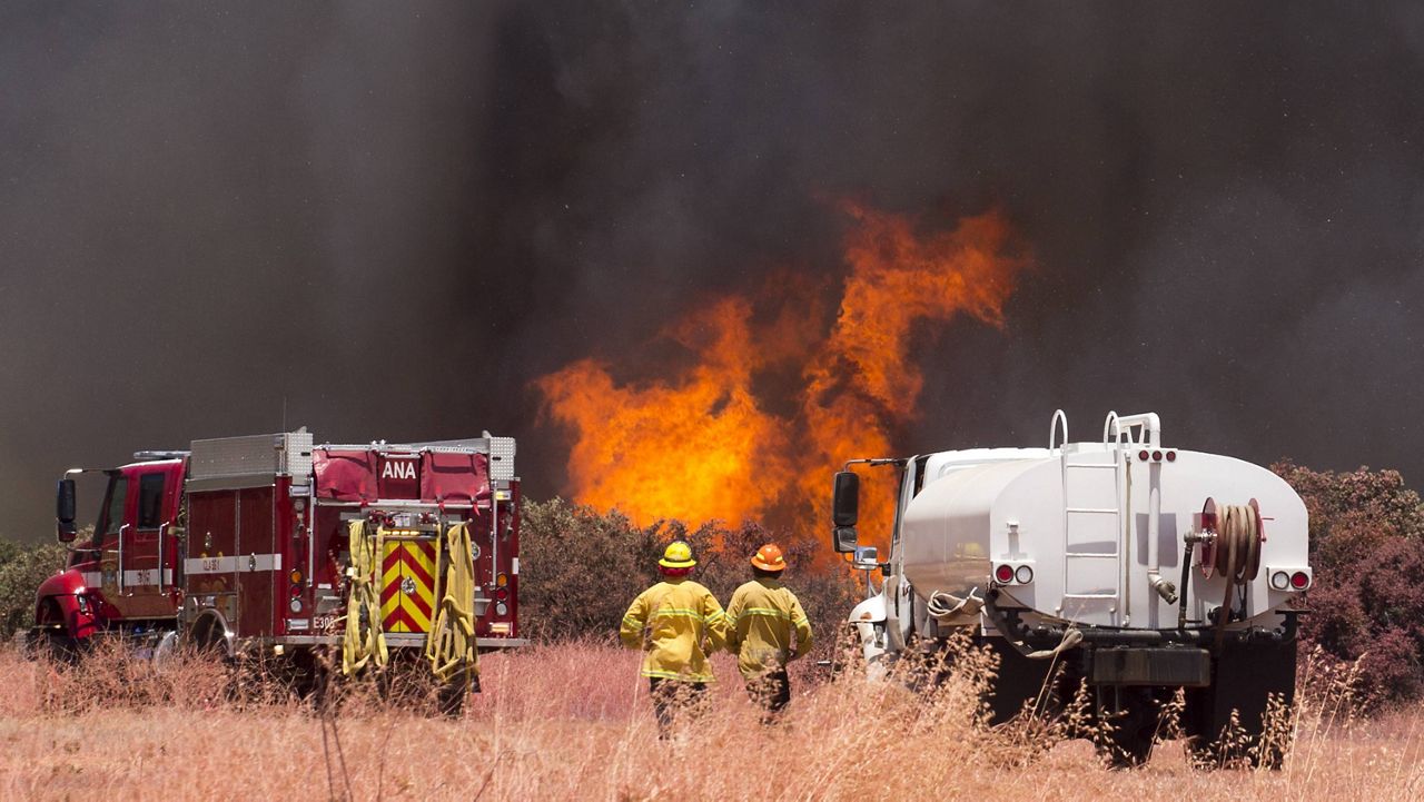 Firefighters watch the Apple Fire in Cherry Valley on Aug. 1. (AP Photo/Ringo H.W. Chiu)