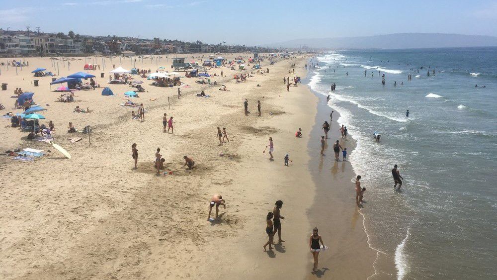 Visitors crowd the beach in Manhattan Beach, amid the coronavirus pandemic Saturday. The heatwave brought dangerously high temperatures, increased wildfire danger, and fears of coronavirus spread as people flock to beaches and parks for relief. (AP Photo/John Antczak)