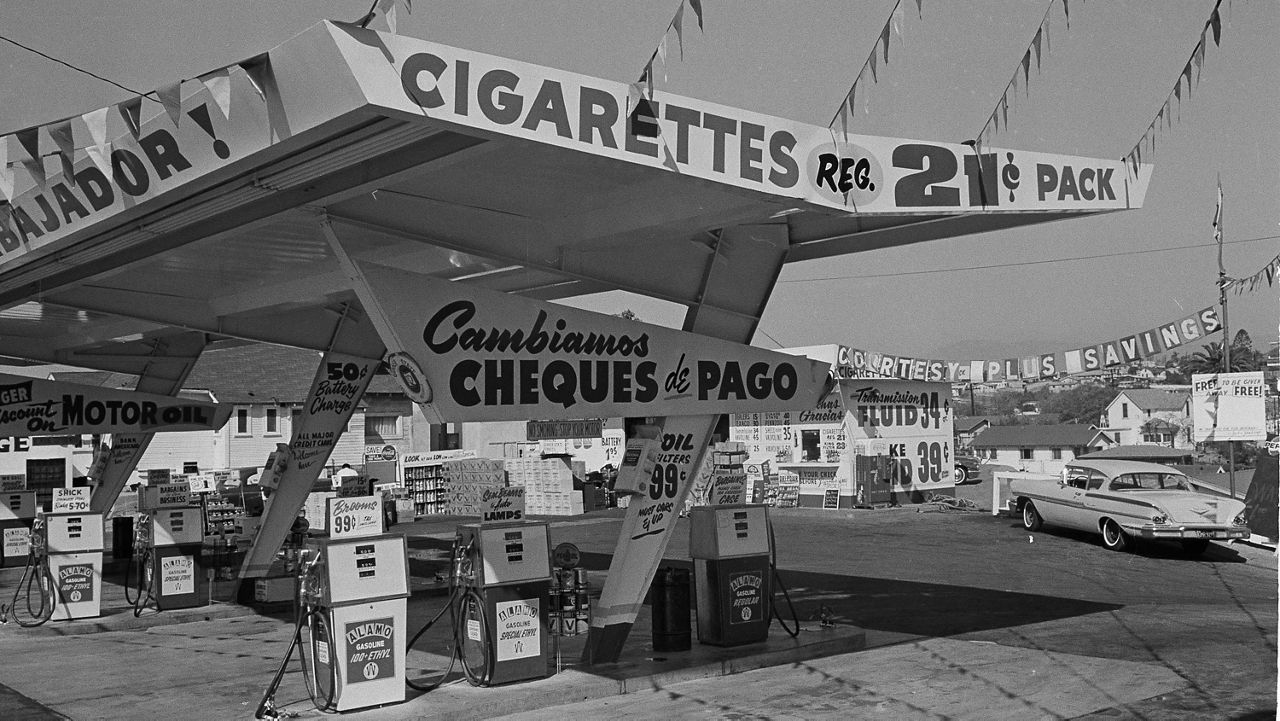 A gasoline station that advertises its paycheck cashing services is seen in the predominantly Mexican-American neighborhood of East Los Angeles, Feb. 14, 1964. The area is also known as the Serape Belt. (AP Photo/Ellis R. Bosworth)