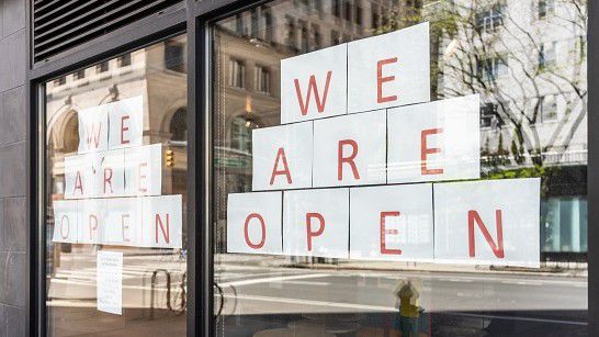 A sign in a window that says "We Are Open" (Spectrum News/File)
