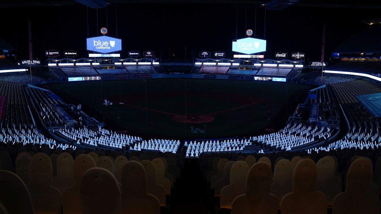 Players leave the field after a power outage during the seventh inning of a baseball game between the Los Angeles Angels and the Los Angeles Dodgers, Saturday, Sept. 26, 2020, in Los Angeles. (AP Photo/Ashley Landis)