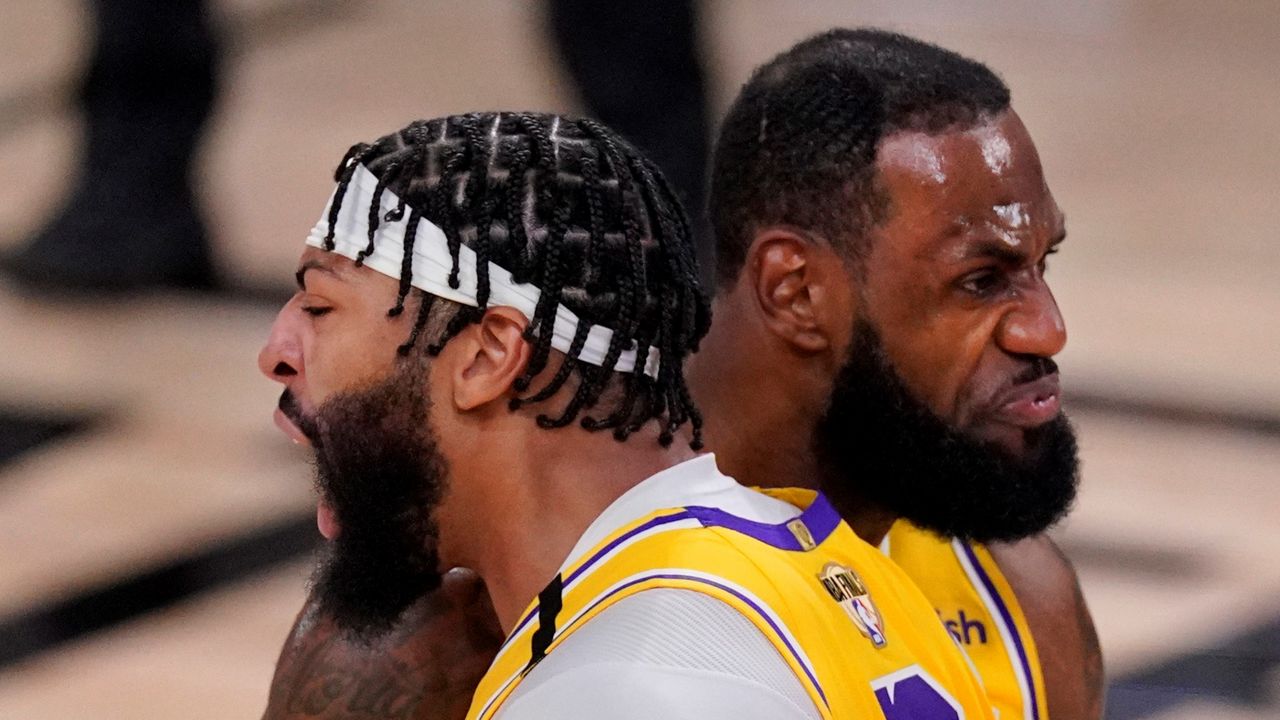 Los Angeles Lakers' Anthony Davis (3) bumps shoulders with LeBron James while celebrating after a dunk against the Miami Heat during the second half of Game 1 of basketball's NBA Finals Wednesday, Sept. 30, 2020, in Lake Buena Vista, Fla. (AP Photo/Mark J. Terrill)