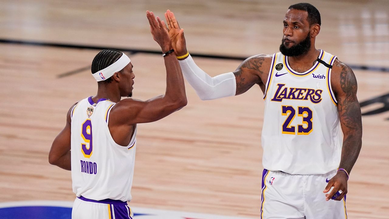 Los Angeles Lakers' LeBron James (23) high fives Los Angeles Lakers' Rajon Rondo (9) during the second half in Game 3 of basketball's NBA Finals, Sunday, Oct. 4, 2020, in Lake Buena Vista, Fla. (AP Photo/Mark J. Terrill)