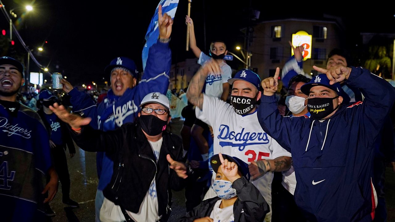 Los Angeles Dodgers fans celebrate on Sunset Blvd. after watching the broadcast of Game 6 of the baseball World Series in Los Angeles on Tuesday, Oct. 27, 2020. The Los Angeles Dodgers defeated the Tampa Bay Rays 3-1 and won the World Series. (AP Photo/Damian Dovarganes)