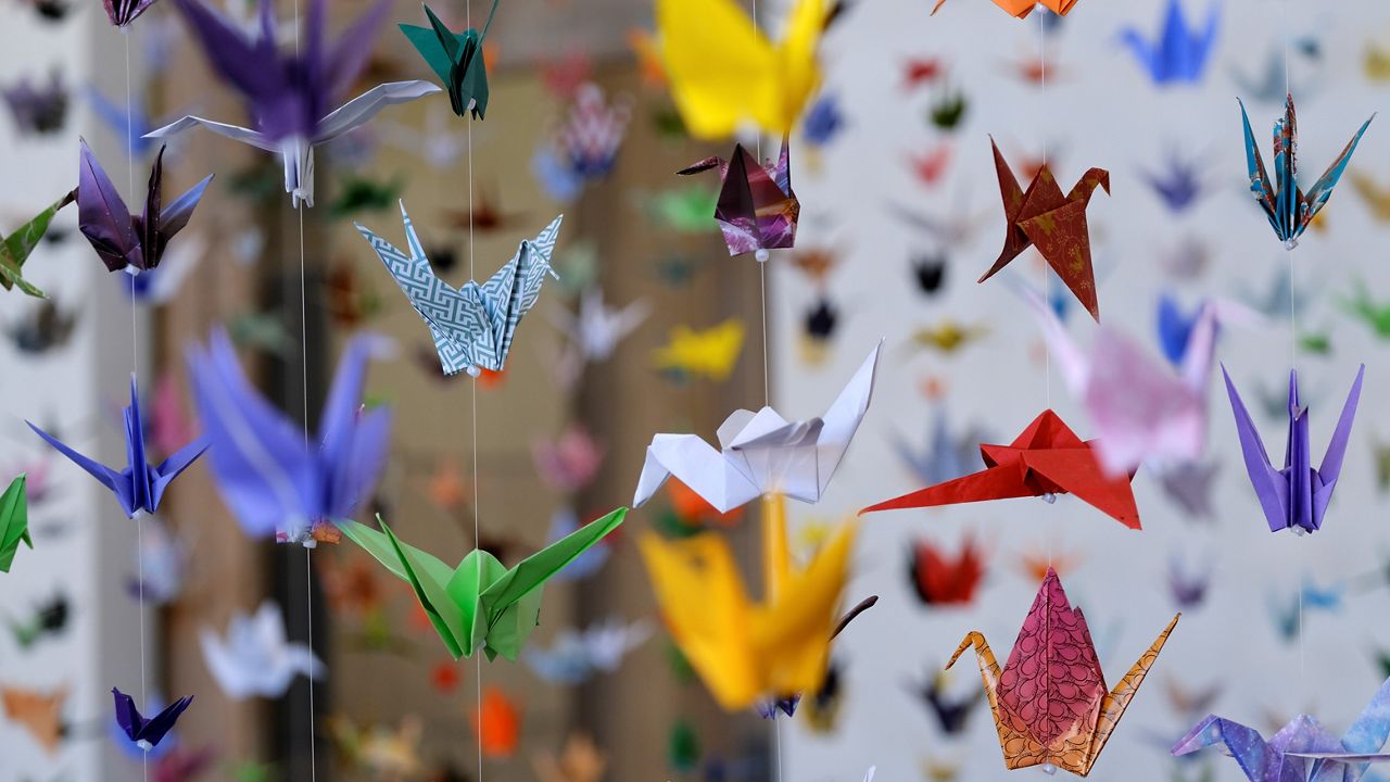 Origami cranes hang during an exhibit "Honoring Matter, A Memorial for the Victims of Covid-19" who have died in the U.S. at the Matter Studio Gallery in Los Angeles. (AP Photo/Richard Vogel)