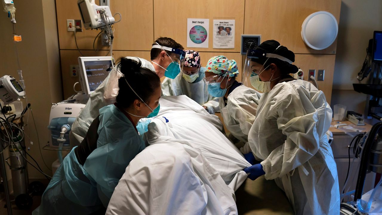 In this Nov. 19, 2020, file photo, medical personnel prone a COVID-19 patient at Providence Holy Cross Medical Center in the Mission Hills section of Los Angeles. The raging coronavirus pandemic has prompted Los Angeles County to impose a lockdown to prevent the caseload from spiraling into a hospital crisis but the order stops short of a full business shutdown that could cripple the holiday sale season. (AP Photo/Jae C. Hong, File)