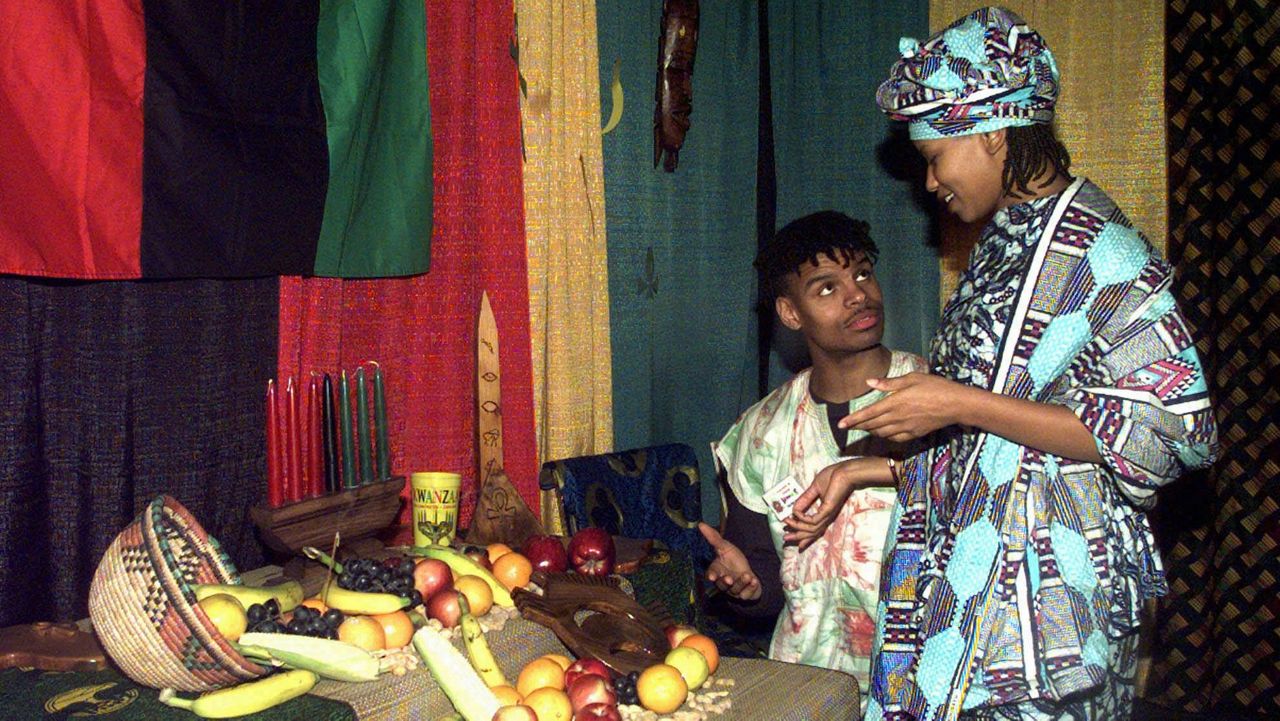 In this file photo from Dec. 5, 1997, Ell-Hajj Malik and Jamala Loff, both of St. Louis, examine the kwanza display in the House of Kwanza, inside the St. Louis convention center, in St. Louis. Kwanza is a celebration of African-American culture and cooperative economics in the country. (AP Photo/James A. Finley)