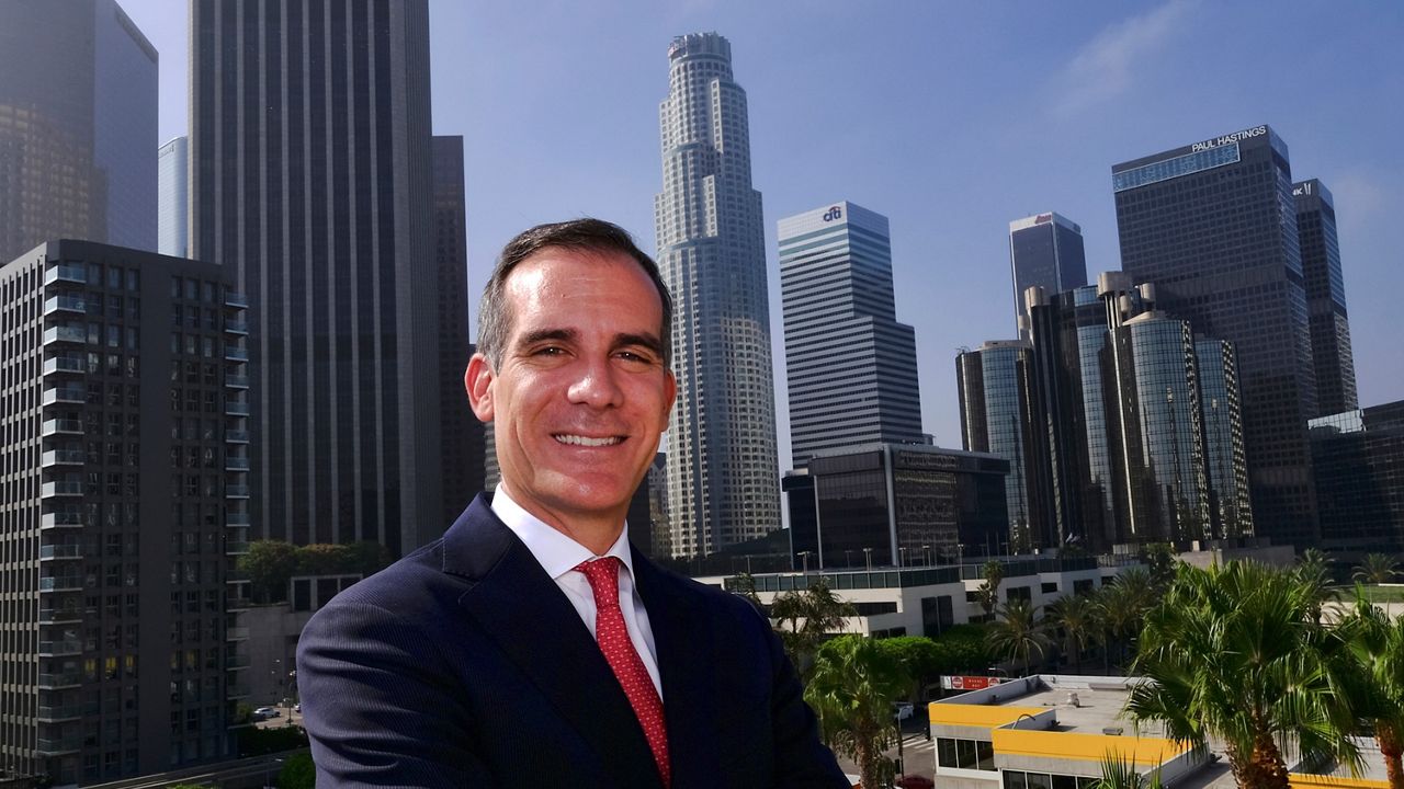In this file photo from Aug. 23, 2018, Los Angeles Mayor Eric Garcetti poses in front of a sprawling downtown Los Angeles landscape. (AP Photo/Richard Vogel, File)