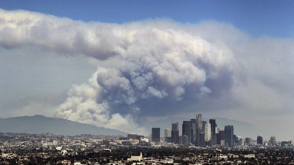 In this file photo from June 20, 2016, smoke from wildfires burning in Angeles National Forest fills the sky behind the Los Angeles skyline. (AP/Ringo H.W. Chiu)