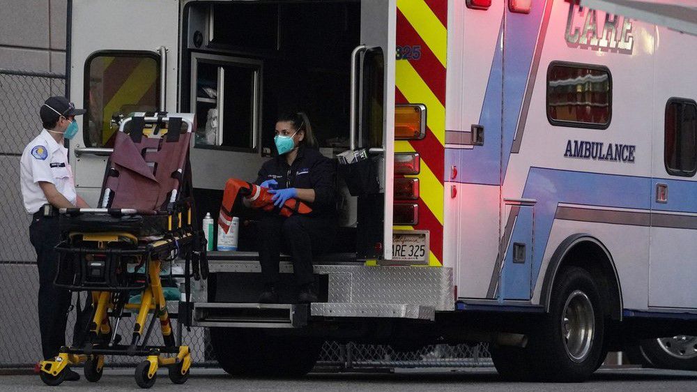 Emergency medical technicians sanitize their ambulance after transporting a patient at Los Angeles County + USC Medical Center in Los Angeles Tuesday, Jan. 5, 2021. Los Angeles continues to see hospitalizations rise day after day, setting a new record Tuesday with almost 8,000 hospitalized and more than a fifth of those in intensive care units. (AP Photo/Damian Dovarganes)