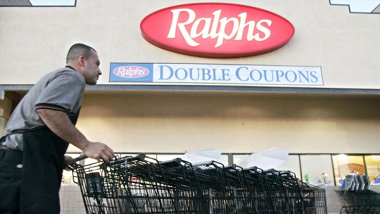 Worker collects shopping carts outside Ralphs grocery store in Los Angeles. (AP)