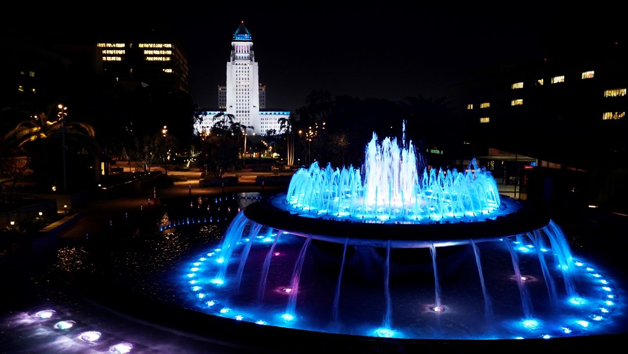 Los Angeles City Hall and a nearby fountain are lit in "Dodger blue" in tribute to the late longtime Los Angeles Dodgers baseball manager Tommy Lasorda, Friday, Jan. 8, 2021. (AP Photo/Chris Pizzello)