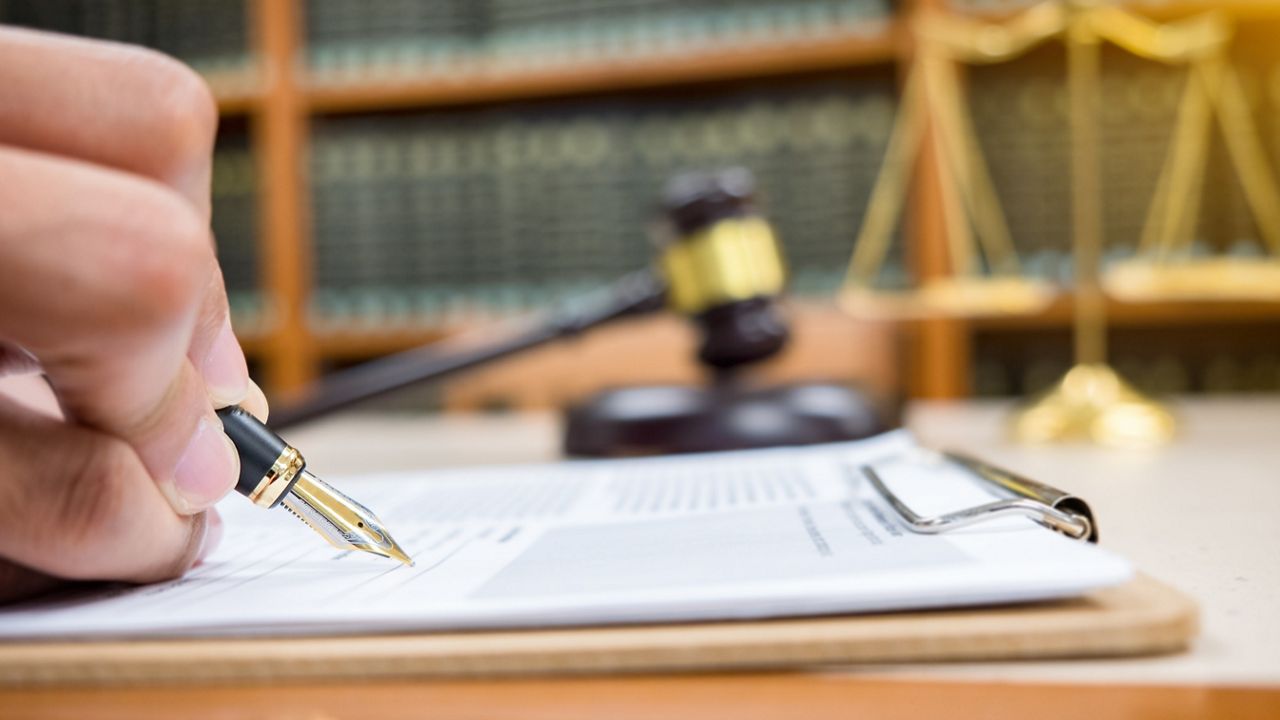 lawyer Detail of a judge sitting at his desk, studying new laws and legislation and taking notes. Selective focus