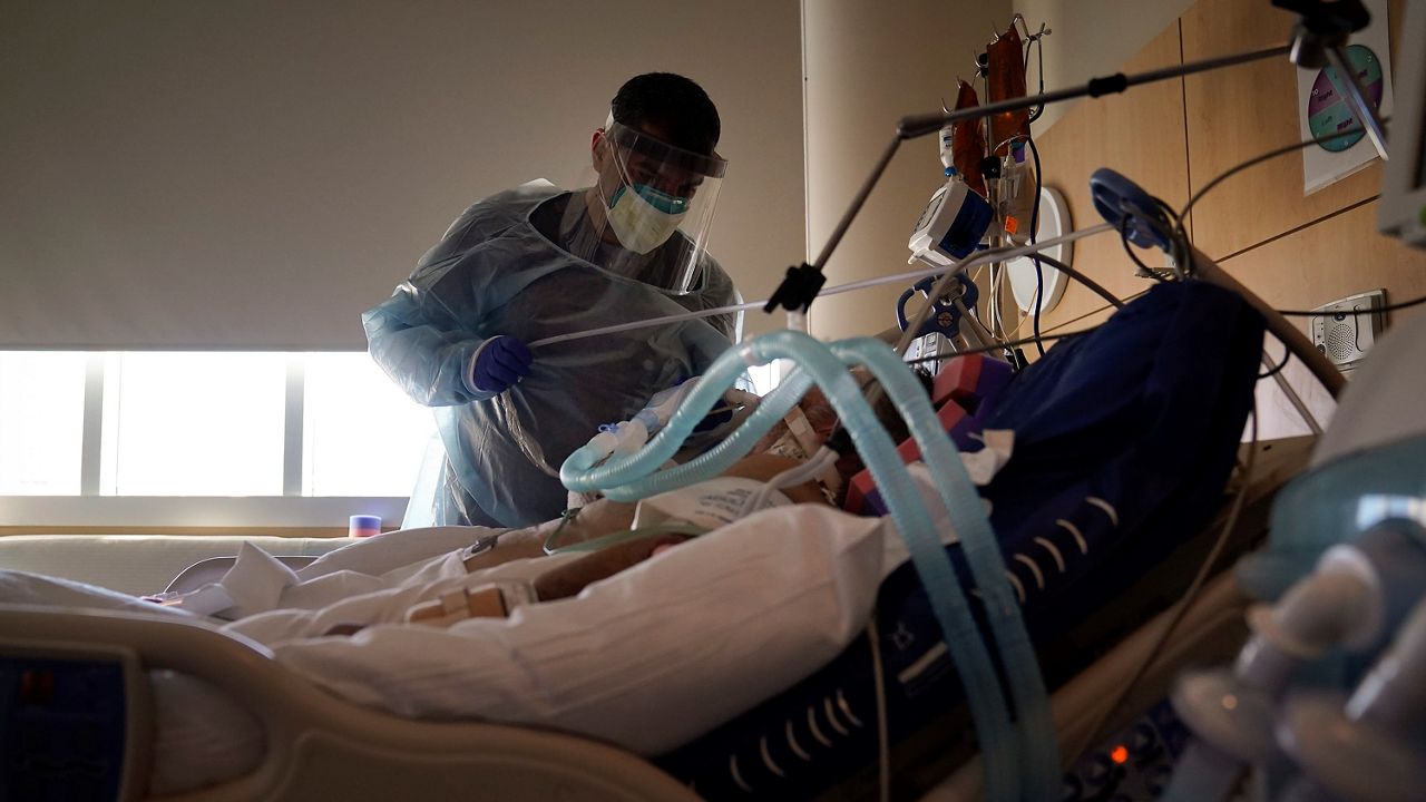 In this file photo from Dec. 22, 2020, Dr. Mher Onanyan tends to a COVID-19 patient at Providence Holy Cross Medical Center in Mission Hills. (AP Photo/Jae C. Hong)