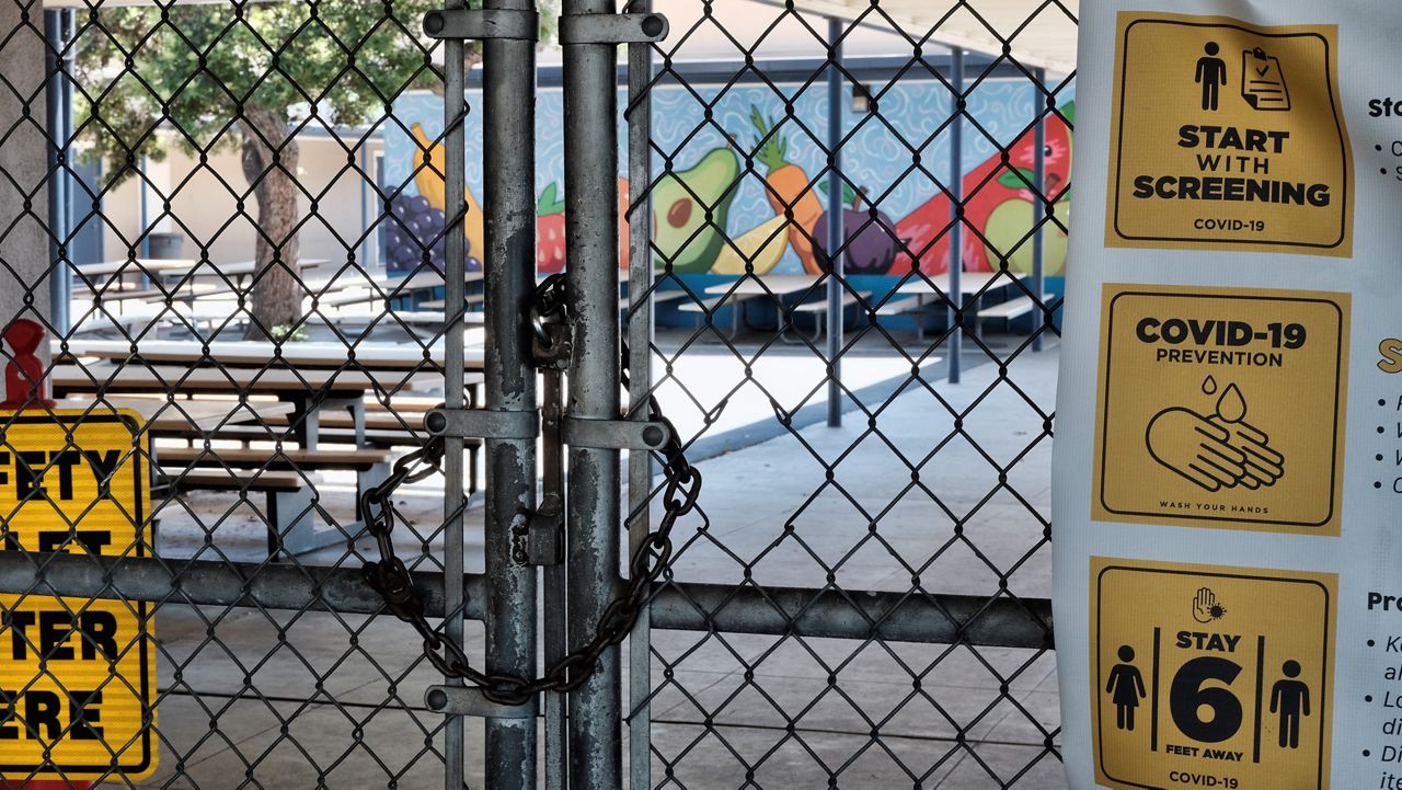 In this file photo from July 13, 2020, a chain link fence lock is see on a gate at a closed Ranchito Elementary School in the San Franando Valley section of Los Angeles. (AP Photo/Richard Vogel)