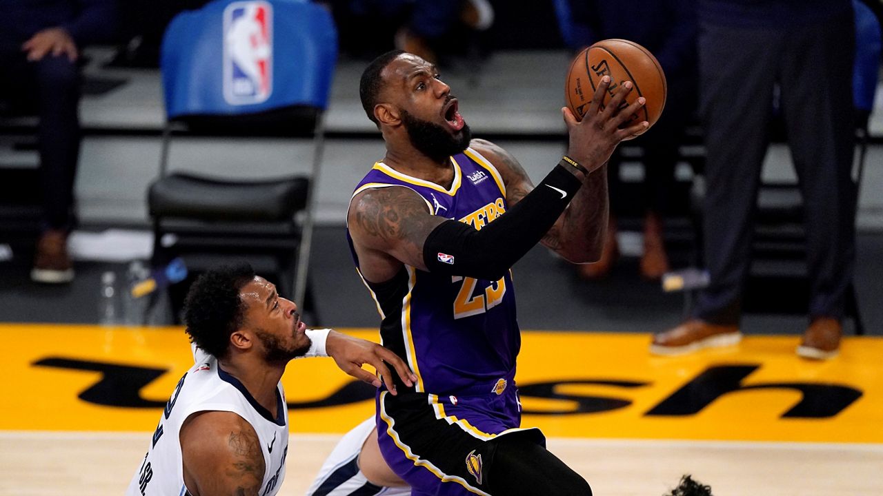 Los Angeles Lakers forward LeBron James, right, goes to the basket as Memphis Grizzlies center Xavier Tillman defends during the first half of an NBA basketball game Friday, Feb. 12, 2021, in Los Angeles. (AP Photo/Mark J. Terrill)