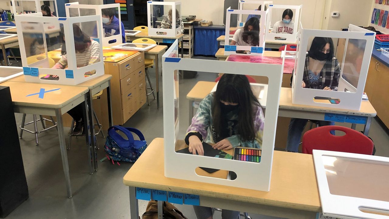 Socially distanced and with protective partitions, students work on an art project during class at the Sinaloa Middle School in Novato, Calif., on Tuesday. The school reopened February 22, 2021, for in-person learning. (AP Photo/Haven Daily)