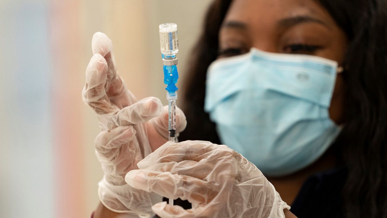 In this Thursday, March 11, 2021, file photo, a health worker loads syringes with the vaccine on the first day of the Johnson & Johnson vaccine being made available to residents at the Baldwin Hills Crenshaw Plaza in Los Angeles. California officials say much of the state will be able to reopen next week to indoor activities as coronavirus case rates remain low. At the same time, more than 4 million residents with certain disabilities or health concerns become eligible for a vaccine. (AP Photo/Damian Dovarganes, File)