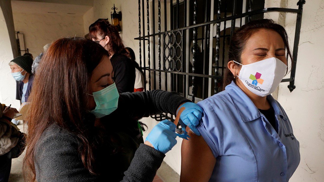 Registered nurse Liliana Ocampo administers a Moderna COVID-19 vaccine to health care worker Gloria Cuaron at The Sisters of St. Joseph of Carondelet independent living center in Los Angeles on March 3, 2021. (AP Photo/Damian Dovarganes)
