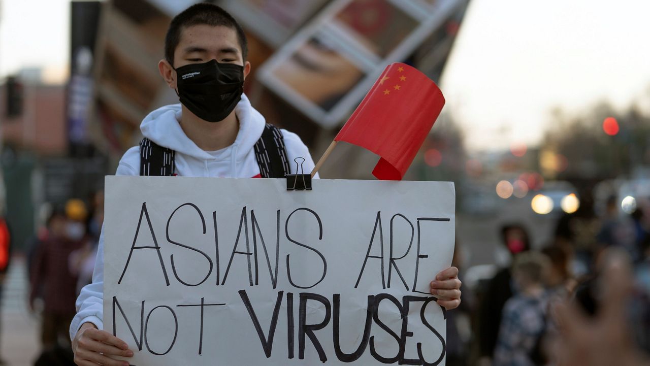 In this March 13, 2021, file photo, a demonstrator participates at a rally to raise awareness of anti-Asian violence outside the Japanese American National Museum in Little Tokyo in Los Angeles. (AP Photo/Damian Dovarganes)