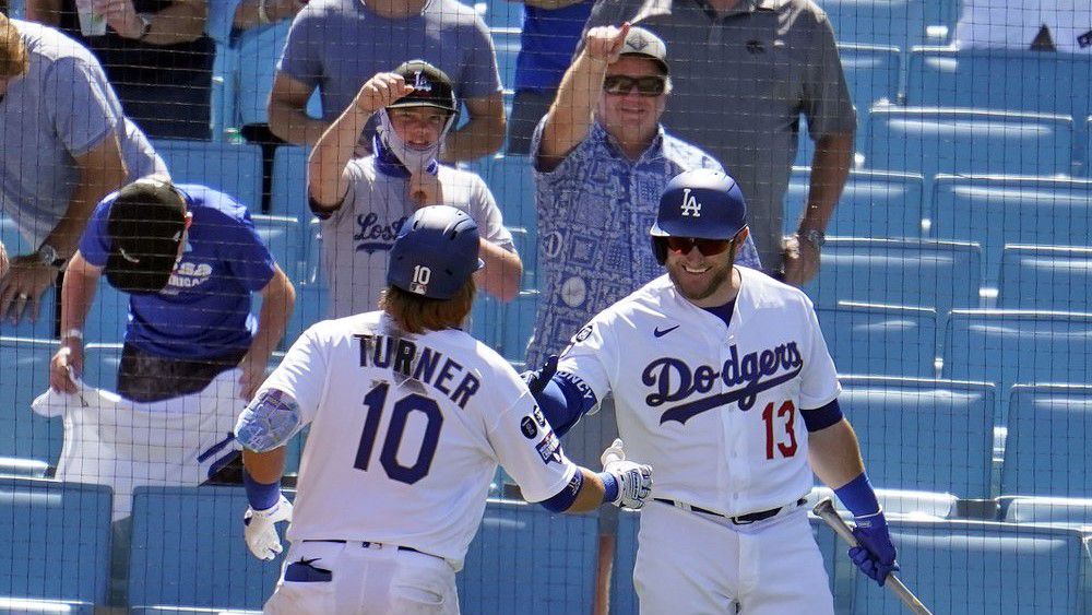 Los Angeles Dodgers' Justin Turner (10) is congratulated by Max Muncy (13) after hitting a solo home run in the sixth inning of a baseball game against the Washington Nationals, Friday in Los Angeles. (AP Photo/Marcio Jose Sanchez) 	 