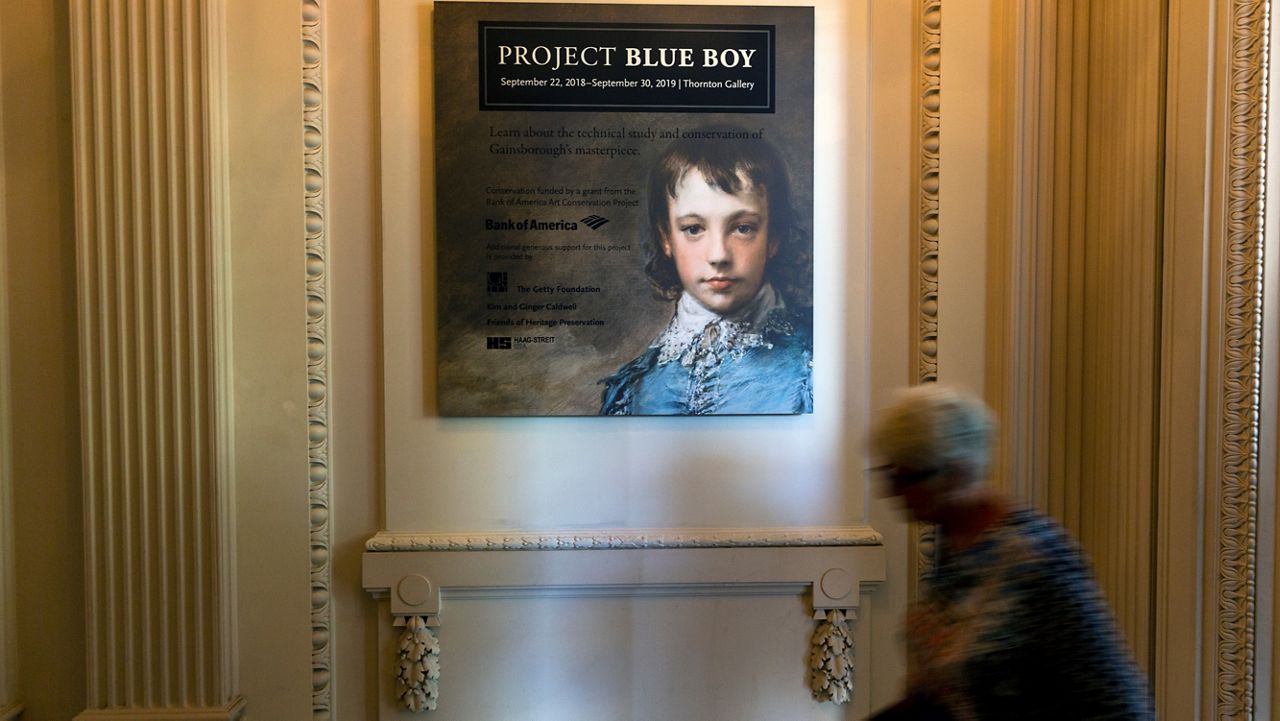 In this Sept. 20, 2018, file photo, Christina O'Connell shows a x-ray display of the "The Blue Boy" painting, made around 1770 by the English painter Thomas Gainsborough (1727-1788), on display at the "Project Blue Boy" exhibit in the Thornton Portrait Gallery at The Huntington in San Marino. (AP Photo/Damian Dovarganes)