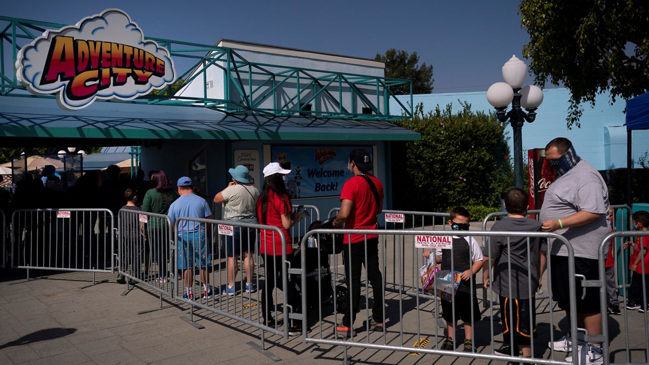People wait in line to enter Adventure City amusement park on the day of reopening in Anaheim. The family-run amusement park that had been shut since March last year because of the coronavirus pandemic reopened on April 16. (AP Photo/Jae C. Hong)  