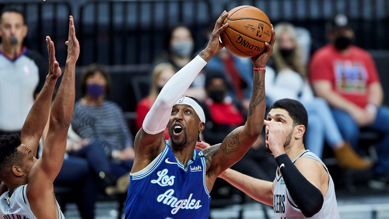 Los Angeles Lakers guard Kentavious Caldwell-Pope, center, shoots between Portland Trail Blazers guard CJ McCollum, left, and center Enes Kanter during the first half of an NBA basketball game Friday in Portland, Ore. (AP Photo/Craig Mitchelldyer)