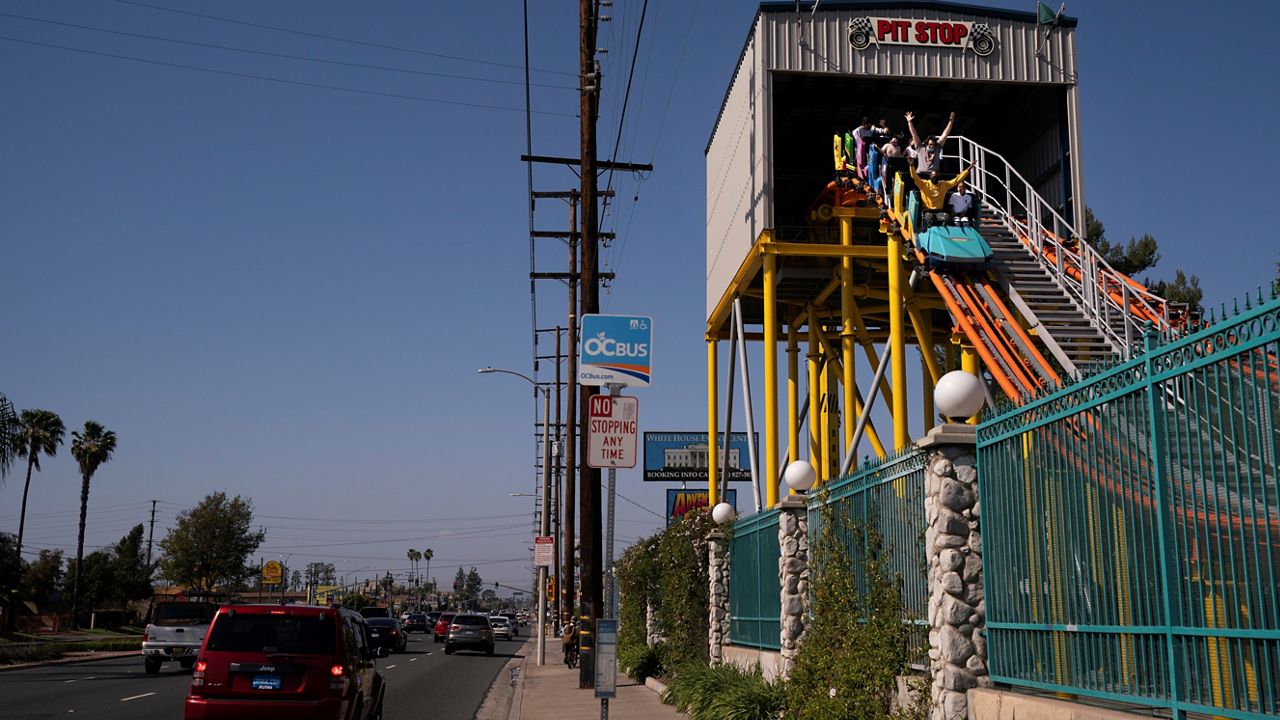 In this April 16, 2021, file photo, visitors ride a roller coaster at Adventure City amusement park on the day of reopening in Anaheim. (AP Photo/Jae C. Hong)