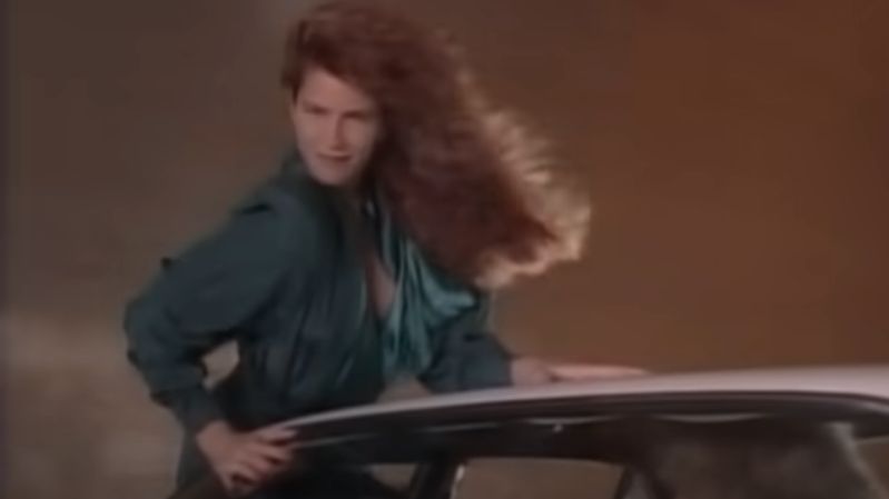 A still from Whitesnake's "Here I Go Again" music video released in the '80s shows actress and model Tawny Kitaen dancing on a car.