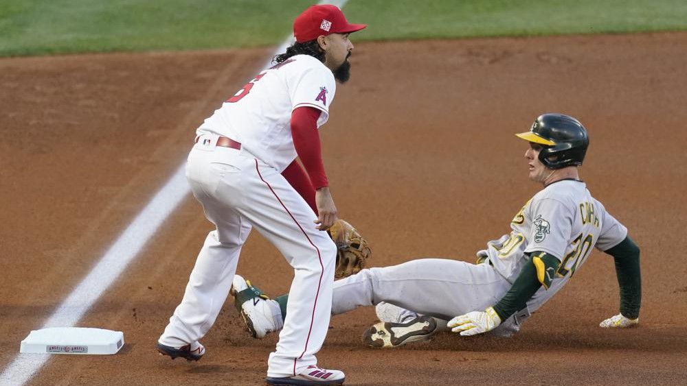 Oakland Athletics' Mark Canha (20) reaches third base ahead of a throw to Los Angeles Angels third baseman Anthony Rendon (6) during the first inning of a baseball game Saturday in Anaheim, Calif. (AP Photo/Ashley Landis)