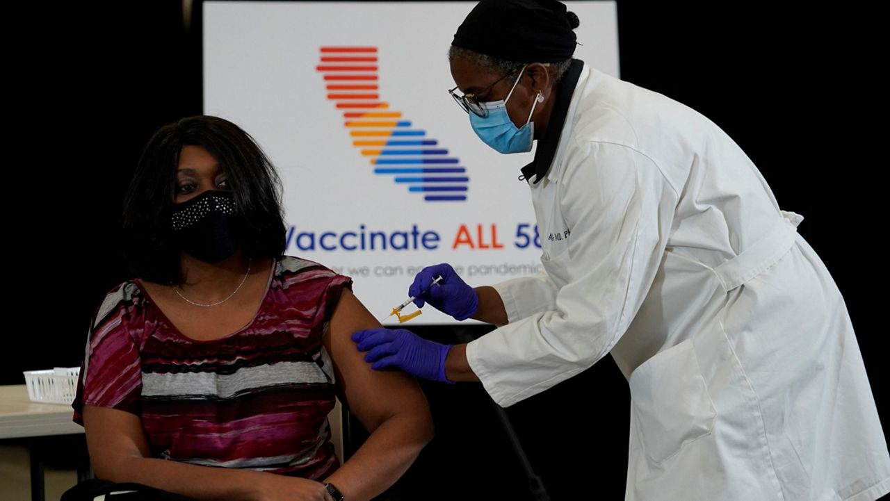 Dr. Arleen Brown, right, inoculates Yolanda Richardson, Government Operations Agency Secretary at State of California, with the Johnson and Johnson COVID-19 vaccine at the Baldwin Hills Crenshaw Plaza, a shopping mall in a historically Black neighborhood southwest of downtown Los Angeles on April 1, 2021. (AP Photo/Damian Dovarganes)