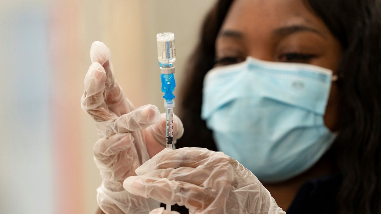In this March 11, 2021, file photo, a health worker loads syringes with the vaccine on the first day of the Johnson & Johnson vaccine being made available to residents at the Baldwin Hills Crenshaw Plaza in Los Angeles. (AP Photo/Damian Dovarganes, File)