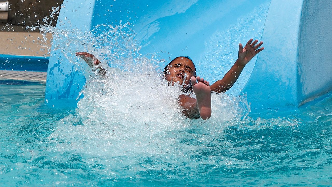 Analeigh Shaw, 10, makes a splash as she hits the water after a ride down the waterslide in this July 9, 2020, file photo. (AP Photo/Keith Srakocic)