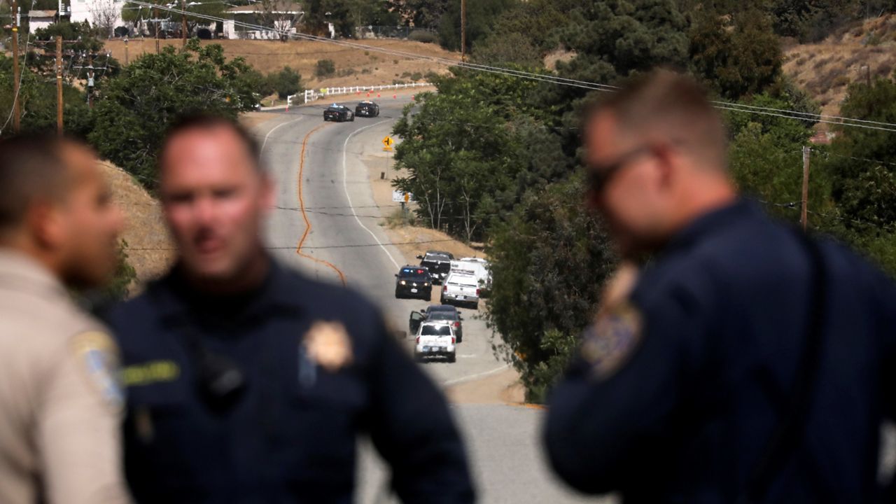 Law enforcement authorities close off a road during an investigation for a shooting Tuesday at fire station 81 in Santa Clarita, Calif. (AP Photo/David Swanson)