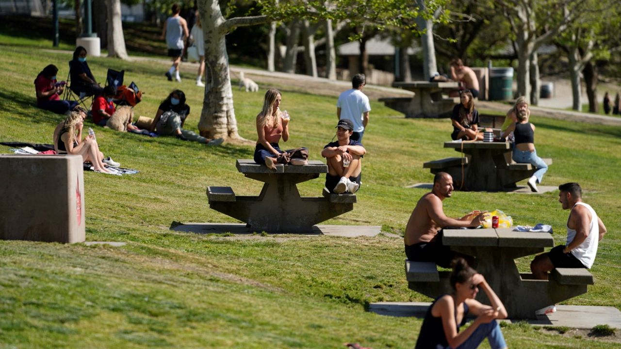 In this April 8, 2021, file photo, people enjoy the sunny weather at Pan Pacific Park in the Fairfax District of Los Angeles. (AP Photo/Damian Dovarganes)