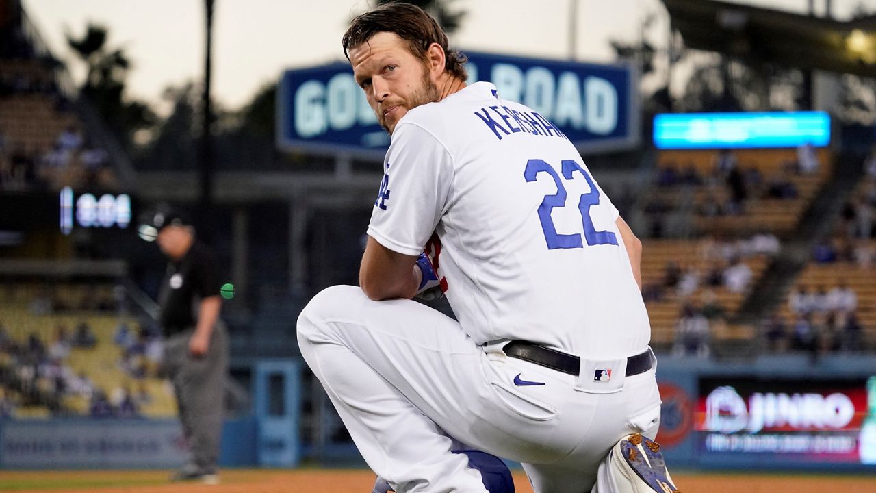 Los Angeles Dodgers' Clayton Kershaw kneels at first as he waits for a pitching change during the third inning of a baseball game Friday against the Texas Rangers in Los Angeles. (AP Photo/Mark J. Terrill)