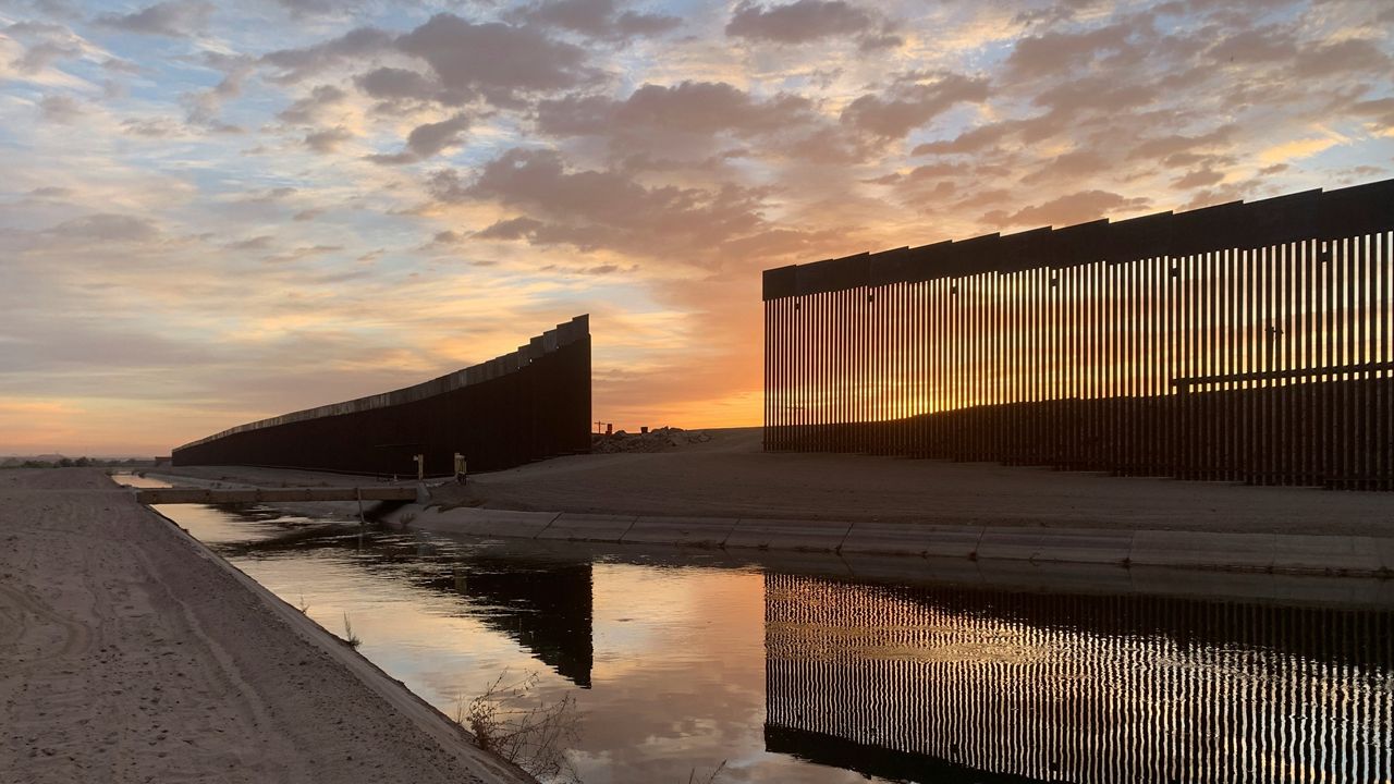 The sun sets above the U.S.-Mexico border wall, seen in Yuma, Ariz., Wednesday, June 9, 2021.