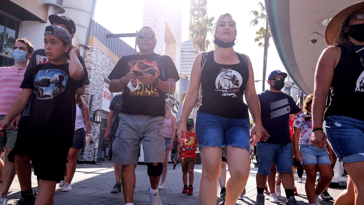People arrive Tuesday at Universal Studios in Universal City, Calif. On Tuesday, California lifted most of its COVID-19 restrictions. (AP Photo/Ringo H.W. Chiu)