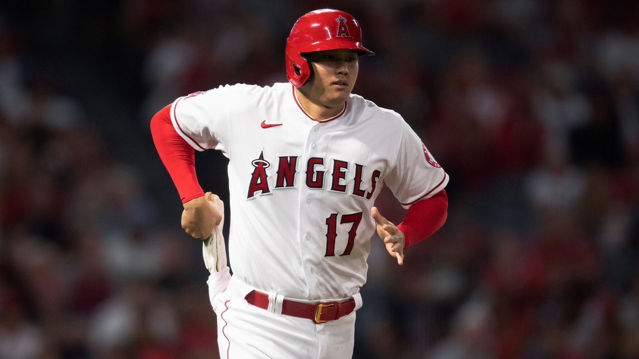 Los Angeles Angels designated hitter Shohei Ohtani pulls gloves for baserunning after drawing an intentional walk during the sixth inning of the team's baseball game Saturday against the Detroit Tigers in Anaheim, Calif. (AP Photo/Kyusung Gong)