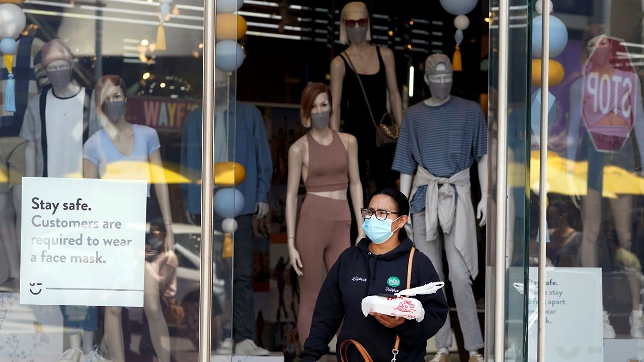 In this May 20, 2021, file photo, mannequins wear masks inside a store at The Grove in Los Angeles amid the pandemic. (AP Photo/Marcio Jose Sanchez)