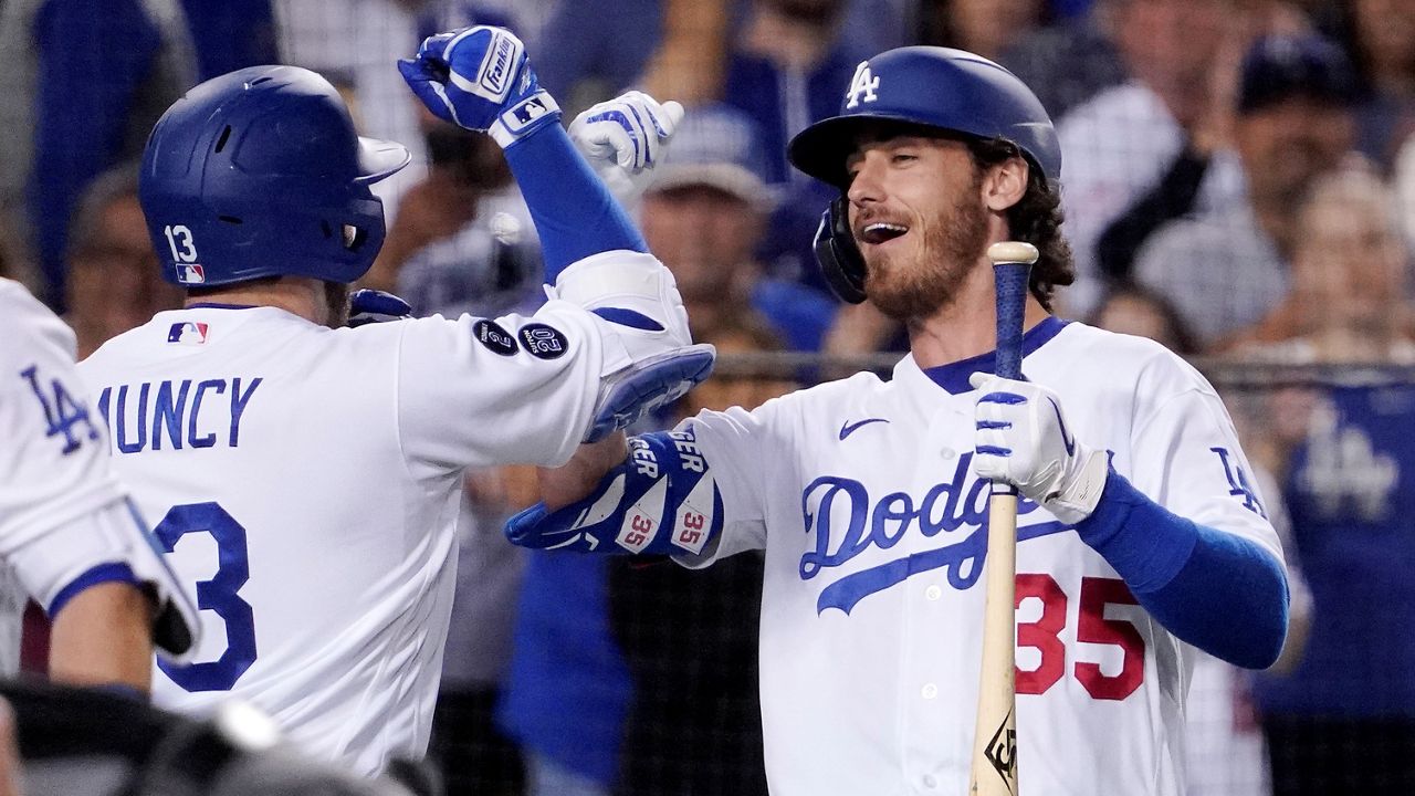 Los Angeles Dodgers' Max Muncy, left, is congratulated by Cody Bellinger after hitting a two-run home run during the eighth inning of a baseball game against the Chicago Cubs Friday in Los Angeles. (AP Photo/Mark J. Terrill)