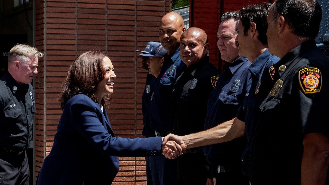 Vice President Kamala Harris, second left, shakes hands with the staff of the Los Angeles Fire Department Brentwood station Sunday in Los Angeles. (AP Photo/Ringo H.W. Chiu)