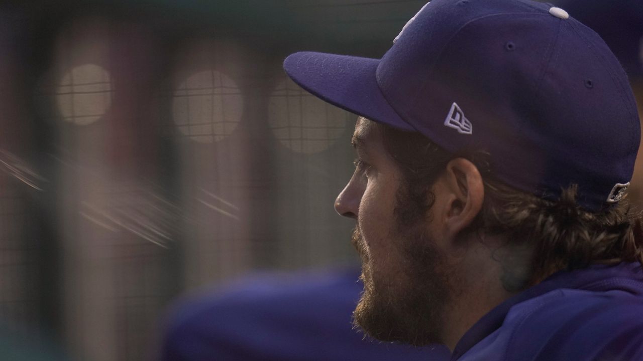 In this July 1, 2021, file photo, Los Angeles Dodgers starting pitcher Trevor Bauer looks on from the dugout during the fourth inning of a baseball game against the Washington Nationals in Washington. (AP Photo/Julio Cortez)