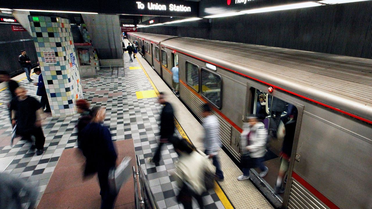 In this April 25, 2012, file photo, commuters enter and exit a train at the MTA Red Line station in Los Angeles. (AP Photo/Reed Saxon)