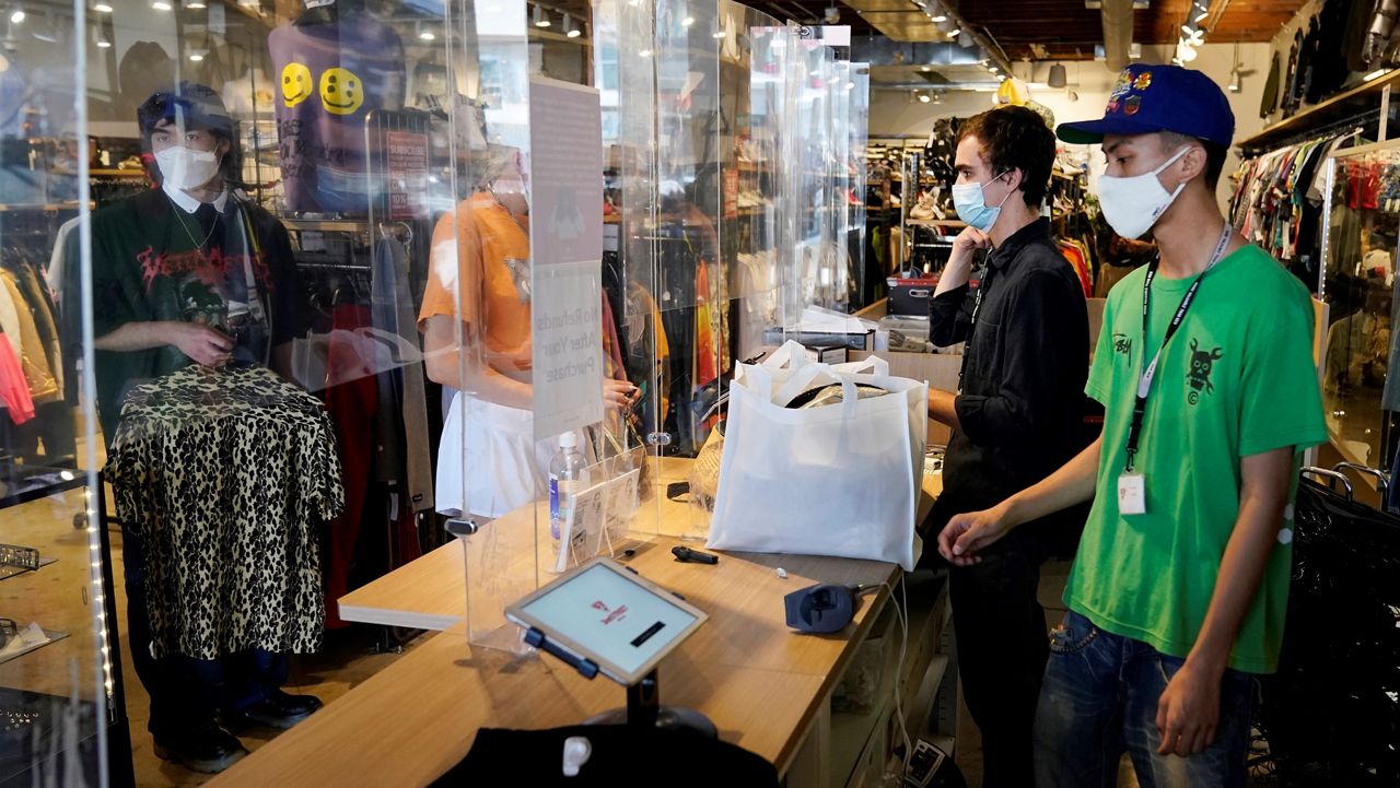 In this July 19, 2021, file photo, employees check out customers at 2nd Street second-hand store in the Fairfax district of Los Angeles. (AP Photo/Marcio Jose Sanchez)