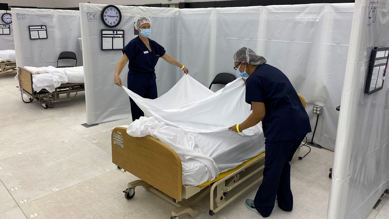Nurses setting hospital bed. (AP Images)