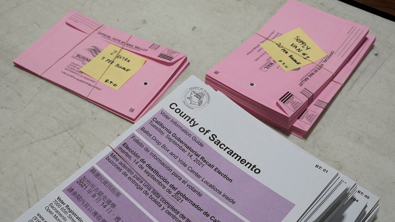 Voters pamphlets and prepaid ballot return envelopes are stacked Wednesday on a table at the Sacramento County Registrar of Voters office in Sacramento, Calif. (AP Photo/Rich Pedroncelli)