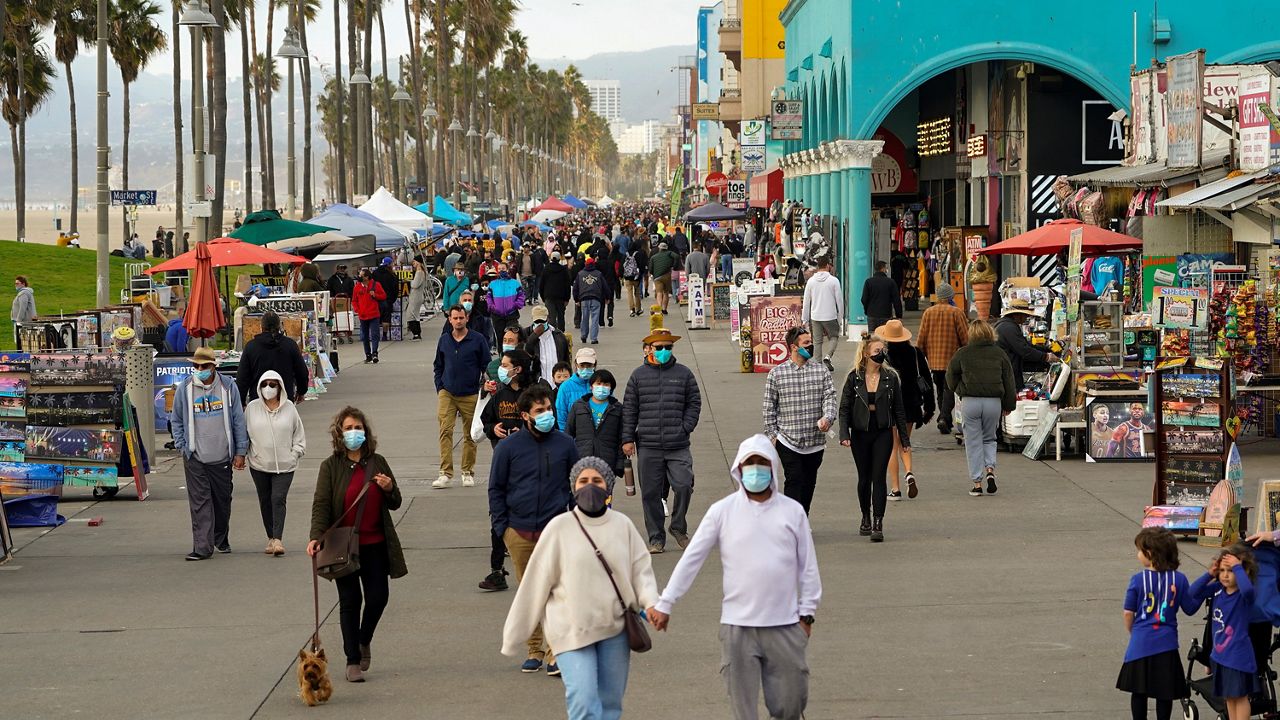 In this Dec. 27, 2020, file photo, people stroll along Venice Beach in Los Angeles. (AP Photo/Damian Dovarganes)